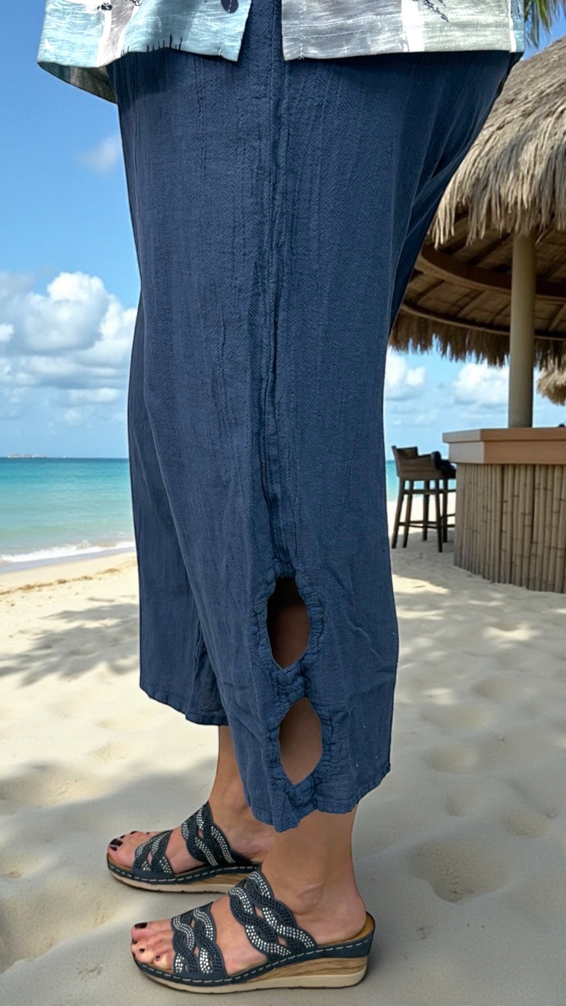 Side view showing circular cut-out details at the hem of cotton gauze pants
